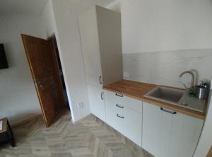 een keuken met witte kasten en een spoelbak bij Pokoje Dębowa in Kazimierz Dolny