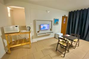 a living room with a table and a microwave at VA Apart Hotel Savassi in Divinópolis