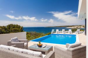 Villa mit Pool, Stühlen und Meerblick in der Unterkunft Villa Jasmina in Gradina