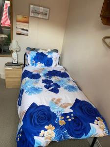 a bed with a blue and white comforter at House 220 in London