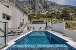 a house with a swimming pool with a mountain in the background at Villa No stress in Drasnice