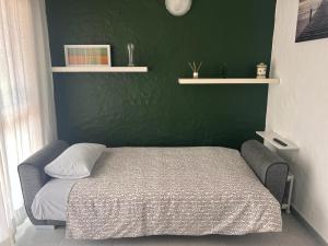 ein Bett in einem Schlafzimmer mit einer grünen Wand in der Unterkunft MAR Y SOL in Maspalomas