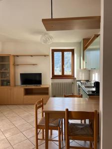 cocina con mesa de madera, sillas y mesa en Villa Linfano Isabel, en Nago-Torbole