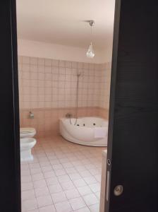 a bathroom with a tub and a toilet at Le Residenze di Niso in Syracuse
