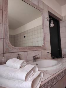 a bathroom with a tub and a mirror and towels at Le Residenze di Niso in Syracuse