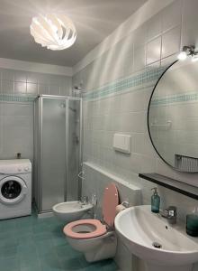 y baño con aseo, lavabo y espejo. en Villa Linfano Isabel, en Nago-Torbole