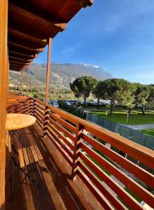 Balcón de madera con mesa y vistas a un campo de golf en Villa Linfano Isabel, en Nago-Torbole