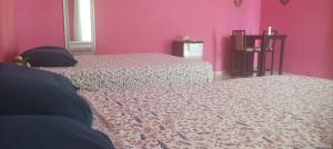 two beds in a room with pink walls at Casas Teoli Casita Rosa in Valladolid