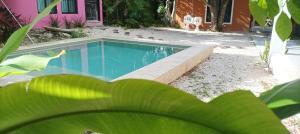 a swimming pool in front of a pink house at Casas Teoli Casita Rosa in Valladolid +8 photos