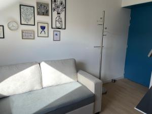 a living room with a couch and some pictures on the wall at Studio cosy in Ham