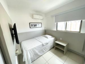 a small white room with a bed and a window at Flat beach Class conselheiro Aguiar in Recife +11 photos