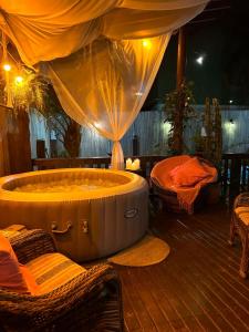 a hot tub in a room with two beds at Studios Malakoopa - Praia do Rosa in Praia do Rosa