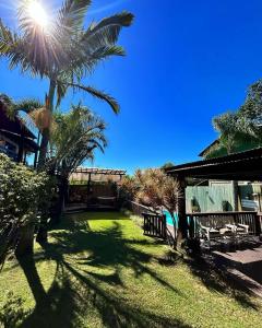 uma palmeira no meio de um quintal em Studios Malakoopa - Praia do Rosa em Praia do Rosa