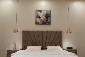 a bedroom with a bed and a painting on the wall at شقق مودرن مقابلة البوليفارد in Riyadh