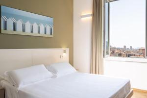 ein weißes Bett in einem Zimmer mit Fenster in der Unterkunft Le camere sui colli 2 in La Spezia