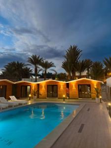 a villa with a swimming pool at night at DownTown Hotel in Dahab
