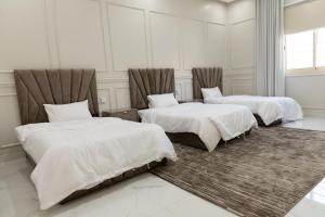a bedroom with two beds with white sheets at شقة مودرن مقابلة البوليفارد in Riyadh