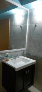 uma casa de banho com um lavatório e um espelho grande em Duplex Esquel em Esquel