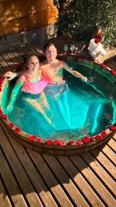two people in a hot tub in a pool at Cabañas Pewma Futrono in Futrono