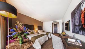 a hotel room with a bed and a table with a vase of flowers at Hotel Morrison Usaquén in Bogotá