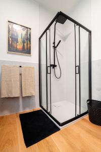 a glass shower in a bathroom with a black rug at Apartament Śnieżne Kotły Ostoja Parku Narodowego in Szklarska Poręba