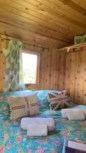 ein Schlafzimmer mit einem Bett mit Kissen darauf in der Unterkunft Willowdene shepherds hut in Oswestry