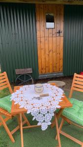 a wooden picnic table with a tablecloth on it at Willowdene shepherds hut in Oswestry