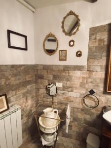 a bathroom with a toilet and a sink and mirrors at Via Castello 17 in Bienno