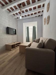 メディナ・シドニアにあるHerrete Roomsのソファとテレビのあるリビングルーム