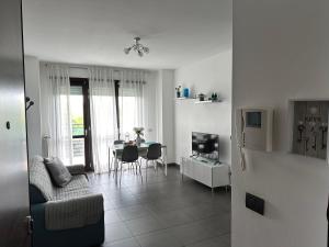 een woonkamer met een bank en een tafel met een televisie bij Ginevra Home in Sesto San Giovanni