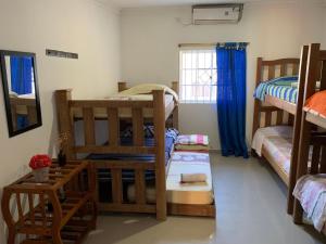 a room with two bunk beds and a window at Hostal Buena Vida in Taganga