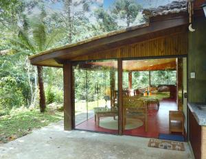 a glass extension of a house in the woods at Casa do Aconchego in Gonçalves