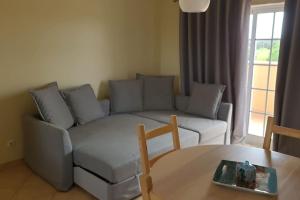 uma sala de estar com um sofá e uma mesa em Stela ' s Guest House em Loulé
