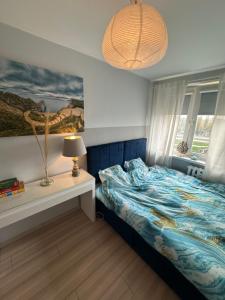 ein Schlafzimmer mit einem Bett und einem Tisch mit einer Lampe in der Unterkunft Gdańska Marina- Śródmieście in Danzig