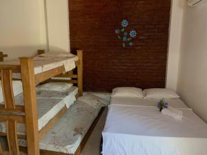 a room with three bunk beds and a brick wall at Hostal Buena Vida in Taganga