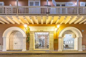 Edificio con 2 puertas blancas y balcón en Hotel Casa del Gobernador en Cartagena de Indias