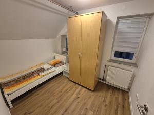 um quarto com uma cama, um armário e uma janela em Orhidea em Liubliana