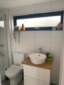 a bathroom with a sink and a toilet and a window at Cedar Cabin in Newbury