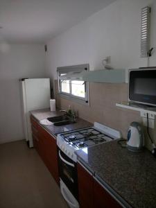 a kitchen with a stove and a sink and a refrigerator at San Isidro in Viedma