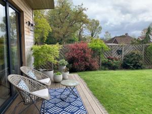 a patio with chairs and a table and a yard at Cedar Cabin in Newbury