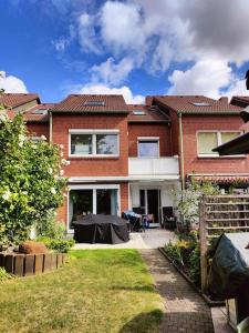 a red brick house with a table in the yard at Reihenhaus mit viel Platz in Hannover