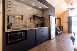 a kitchen with a sink and a microwave at Le Versant Mont-Sainte-Anne in Saint-Férréol-les-Neiges +17 photos