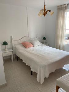 a bedroom with a large white bed with two tables at Ferienwohnung Torrevieja España in Torrevieja