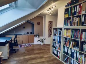 an attic room with bookshelves filled with books at Reihenhaus mit viel Platz in Hannover