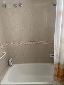 a shower with a white tub and a shower curtain at Ferienwohnung Torrevieja España in Torrevieja