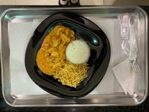 un plato de comida con fideos y arroz en un microondas en Prestige Motel 3, en Sorocaba