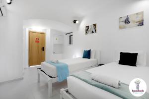 2 letti in una camera con pareti bianche di Villa Sereno ad Albufeira