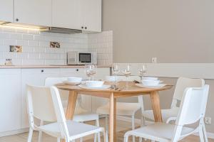 ソポトにあるApartament 17のキッチン(木製テーブル、白い椅子付)