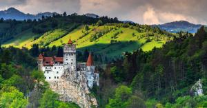 a castle on the side of a mountain at Sinuhe Apartment in Braşov