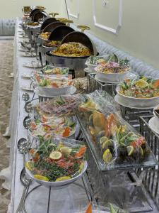 ein Buffet mit vielen Speisen in der Unterkunft شالية المزرعة 